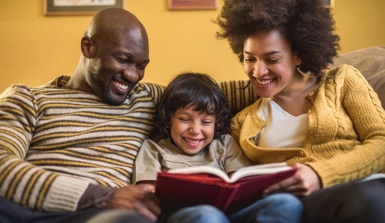 parents reading a book to their kid